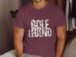 A person wearing a maroon t-shirt with the text "GOLF LEGEND" in white, seated on a couch.