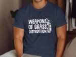 A man wearing a navy blue t-shirt with the text "WEAPONS OF GRASS DESTRUCTION" and a golf bag graphic.