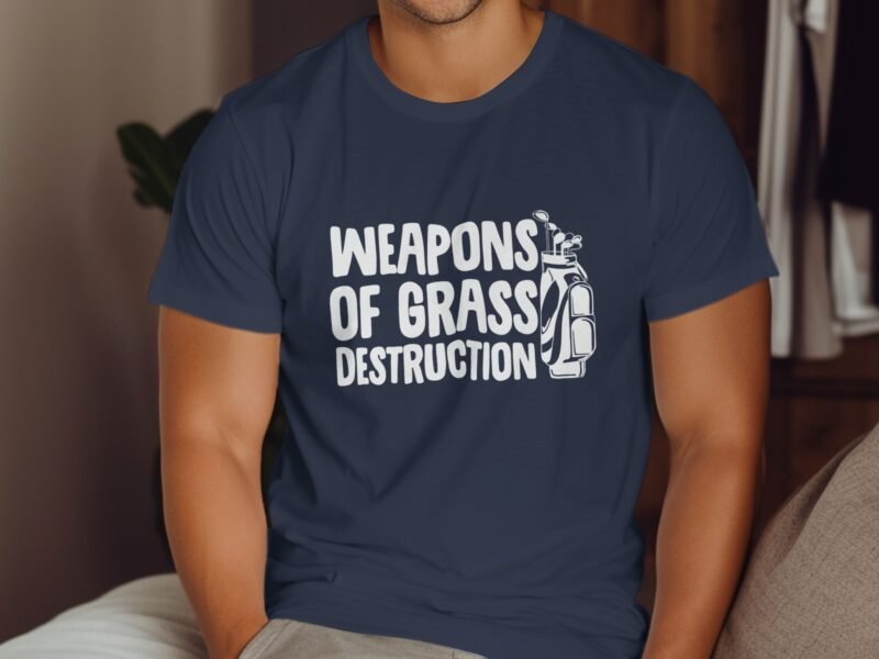 A man wearing a navy blue t-shirt with the text "WEAPONS OF GRASS DESTRUCTION" and a golf bag graphic.