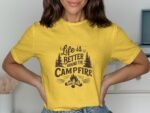 A woman wearing a yellow shirt with the text "Life is Better Around the Campfire," featuring pine trees and a campfire graphic.