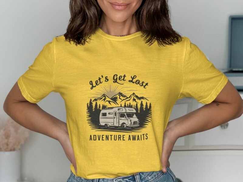 Woman wearing a yellow t-shirt with a camper graphic and the text "Let's Get Lost Adventure Awaits."