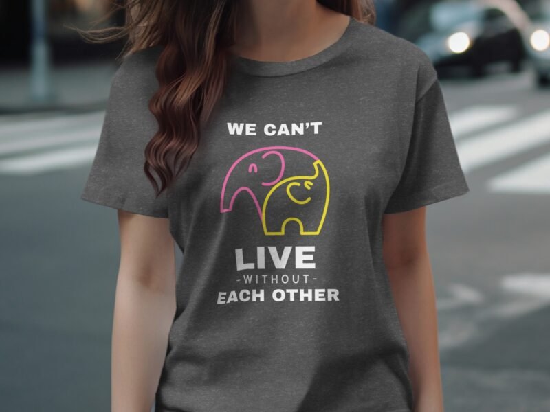 A woman wears a gray t-shirt featuring two colorful elephant graphics and the text: "We can't live without each other."