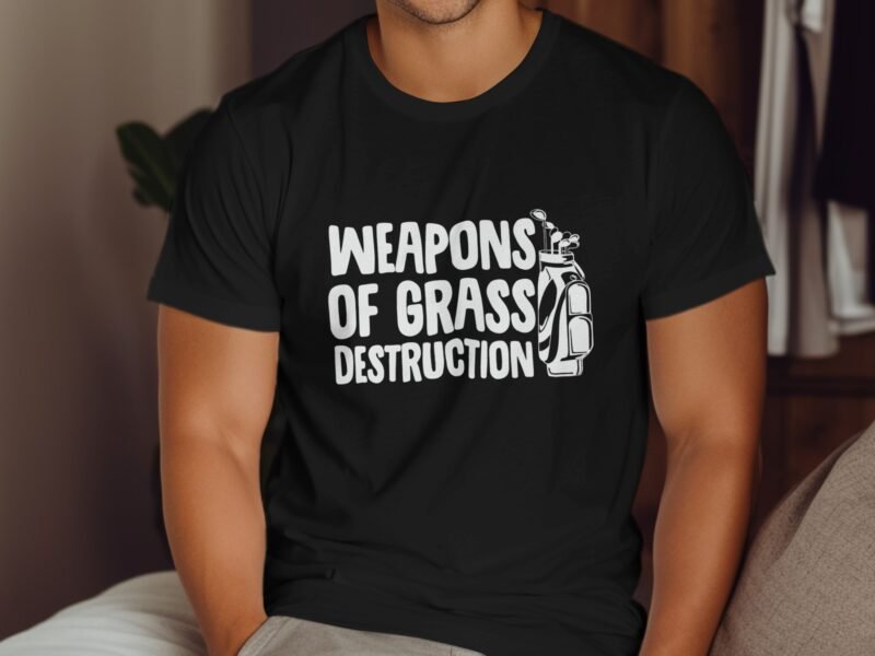 A man in a black t-shirt featuring the phrase "WEAPONS OF GRASS DESTRUCTION" alongside a golf bag graphic.
