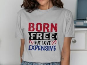 Woman wearing a gray t-shirt with the text "BORN FREE but LOVE EXPENSIVE," in red, black, and blue lettering.