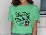 A woman wears a green t-shirt featuring the text “Wine Tasting” and two wine glasses with spilled red wine graphic.
