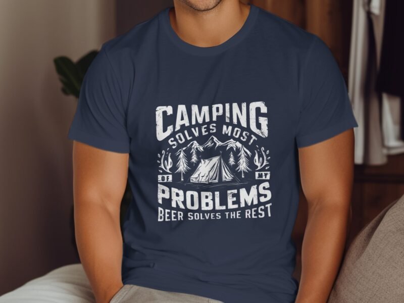 A person wearing a navy blue t-shirt with a camping-themed graphic and text that reads "Camping solves most problems."