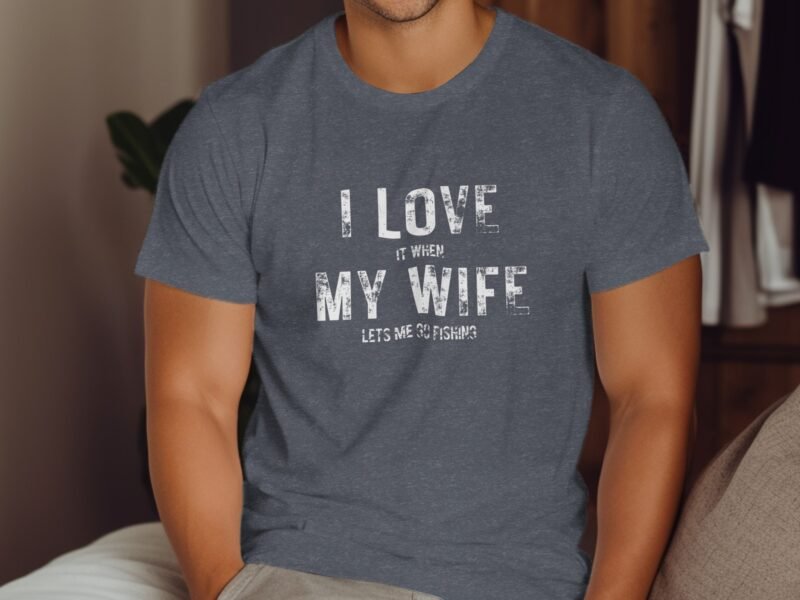 A man in a navy t-shirt with the text "I LOVE it WHEN MY WIFE LETS ME GO FISHING" printed in white.