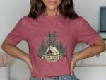 Woman wearing a maroon t-shirt with a "Camp Crew" graphic featuring a tent and pine trees.