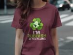 Woman wearing a maroon shirt with a recycling graphic and the text "I'M RUBBISH AT RECYCLING." Background of city street.