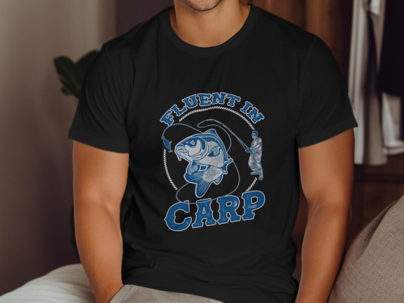 A man wearing a black t-shirt with a graphic of a fishing scene and the text "Fluent in Carp."