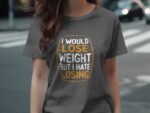 A woman is wearing a gray t-shirt with the humorous text: "I would lose weight but I hate losing."