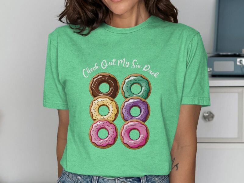 Woman in a green t-shirt featuring six colorful donuts and the phrase "Check Out My Six Pack."