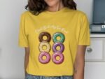 Person wearing a yellow shirt with a graphic of six colorful donuts and the text "Check Out My Six Pack."
