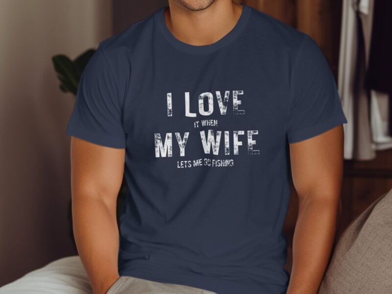 A man in a navy t-shirt with the text "I LOVE IT WHEN MY WIFE LETS ME GO FISHING" displayed prominently.