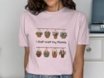 A woman wearing a pink t-shirt with a floral design and the text "I Just Wet My Plants" displayed prominently.