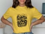 A woman in a yellow t-shirt displays a motivational graphic reading, "Life is a climb but the view is great."