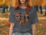 A woman with red hair wears a gray t-shirt featuring a heart design filled with Halloween icons in orange and black.