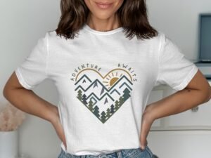Woman wearing a white t-shirt with a heart-shaped mountain graphic and the text "Adventure Awaits."