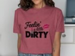Woman wearing a maroon t-shirt with the text "Feelin' a little DIRTY" and a lipstick graphic.