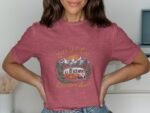 A woman models a pink shirt with a vintage van and mountains graphic, text reads "Let's Get Lost Adventure Awaits."