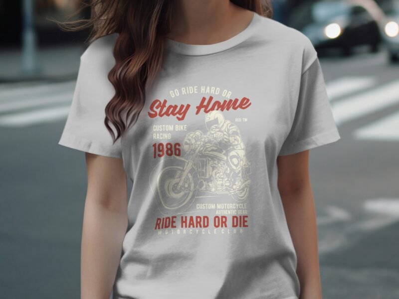 A woman wears a light gray t-shirt featuring motorcycle-themed graphics and text promoting bike culture.