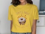 Woman wearing a yellow t-shirt with a cartoon donut graphic and the text "Very Hot Handle With Care."