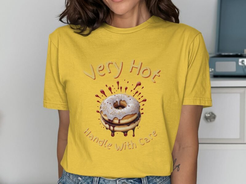 Woman wearing a yellow t-shirt with a cartoon donut graphic and the text "Very Hot Handle With Care."