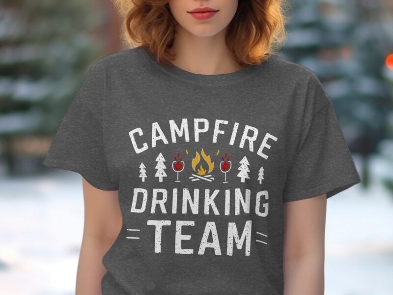 A woman wearing a gray t-shirt with the text "Campfire Drinking Team" and illustrations of trees, drinks, and a campfire.