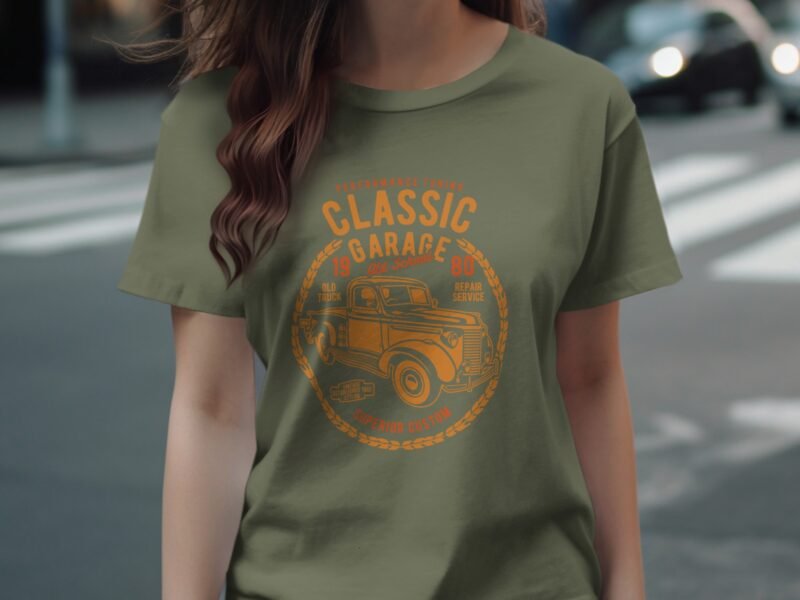 A woman in an olive-green t-shirt featuring a vintage truck graphic and text reading "Classic Garage."