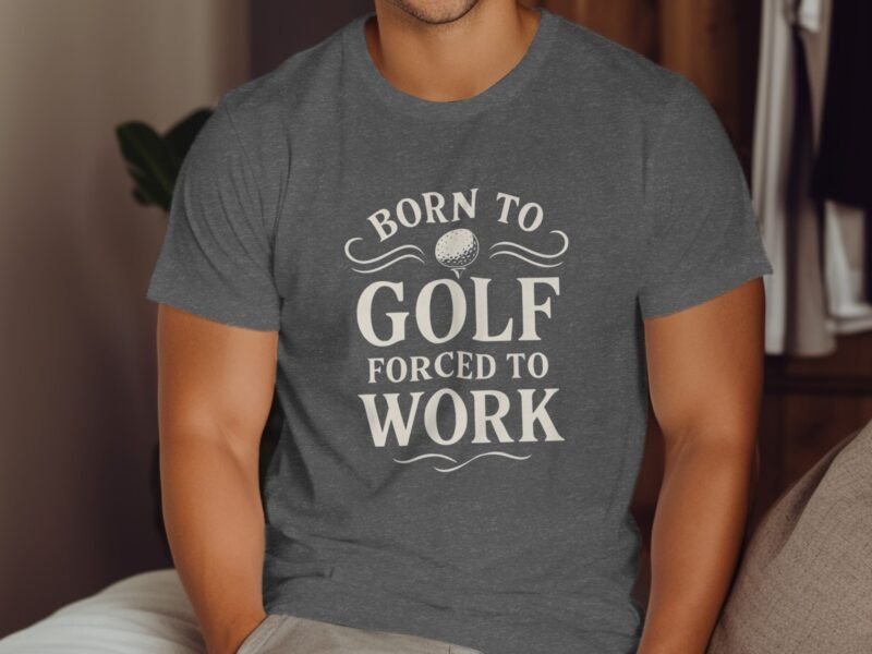 A man in a gray t-shirt with the text "BORN TO GOLF FORCED TO WORK" sits comfortably indoors.