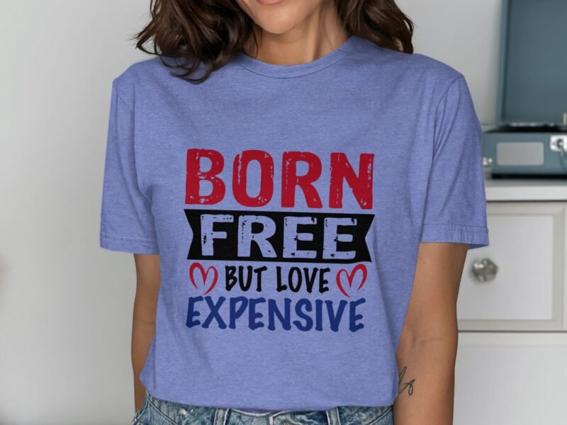 A woman wearing a light blue t-shirt with the text "BORN FREE BUT LOVE EXPENSIVE" in bold, colorful letters.