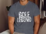 A man wearing a gray t-shirt with the text "GOLF LEGEND" printed in white, sitting on a couch.