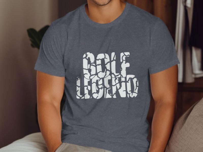 A man wearing a gray t-shirt with the text "GOLF LEGEND" printed in white, sitting on a couch.