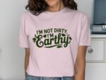 A person is wearing a pink t-shirt with the text "I'M NOT DIRTY, I'M Earthy" in dark green.