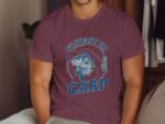 A person wearing a purple t-shirt with "Fluent in Carp" text, featuring a fish and a fisherman illustration.
