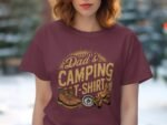 A woman wearing a maroon t-shirt that says "Dad's Camping T-Shirt," featuring camping boots, a wheel, and logs.