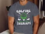 A man wearing a gray t-shirt with the phrase "Golfing Cheaper Than Therapy" and a green golf ball graphic.