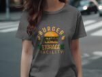 A person wearing a gray t-shirt featuring a colorful burger graphic with the text "BURGER STORAGE FACILITY."