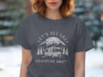 A woman in a gray t-shirt featuring a camping graphic with the text "Let's Get Lost Adventure Awaits."