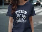 Woman wearing a navy blue shirt with a graphic that says "PISTON BROKE" surrounded by a piston and beer bottles.