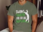 A person wearing a green t-shirt with the text: "SWING, SWEAR, LOOK FOR BALL, REPEAT" and a golf swing graphic.