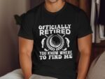 A man wears a black t-shirt with the text "Officially Retired" and golf-themed graphics.