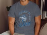 A man in a gray t-shirt with "Fluent in Carp" and an illustration of a fisherman and a carp fish.