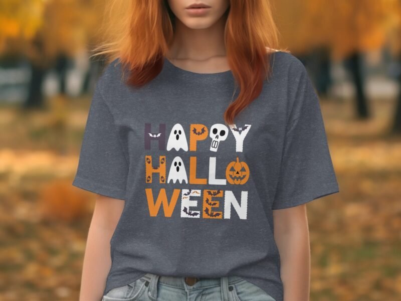 Woman with reddish hair wearing a gray t-shirt that reads "HAPPY HALLOWEEN" in colorful letters, surrounded by autumn foliage.