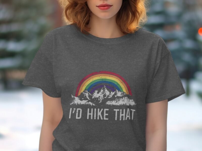Woman wearing a gray t-shirt with a rainbow and mountain graphic, text reads "I'd Hike That."