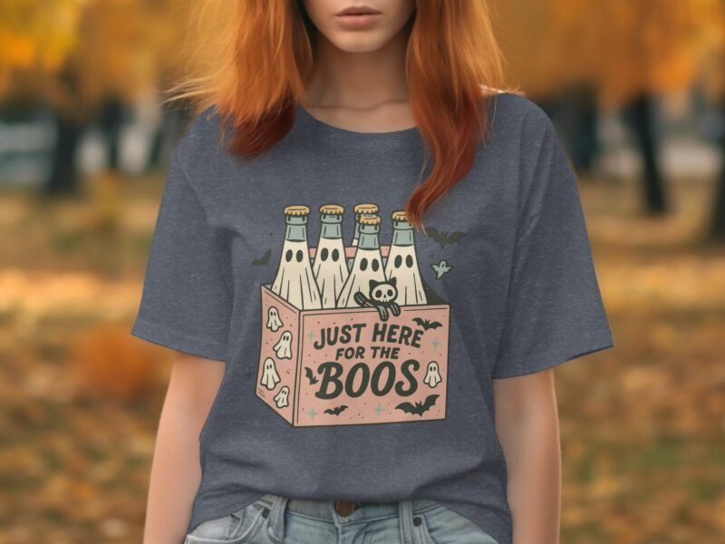 Woman with reddish hair wears a gray t-shirt featuring a cartoon graphic of bottles and the text "Just Here for the Boos."