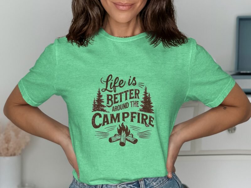 Model wearing a green t-shirt with "Life is Better Around the Campfire" graphic surrounded by trees and a campfire design.