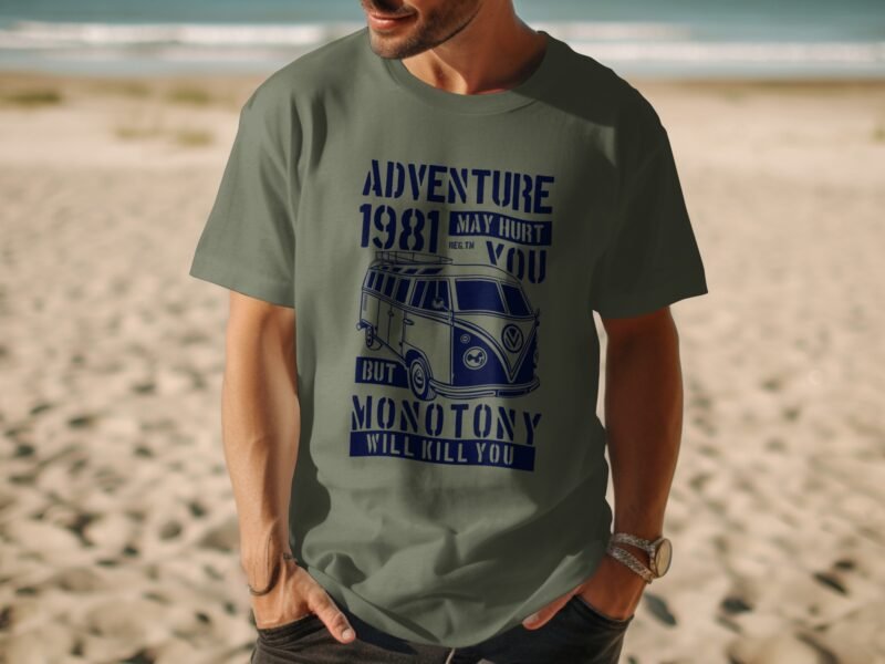Man wearing a green t-shirt with blue text and a vintage van graphic, standing on a sandy beach.
