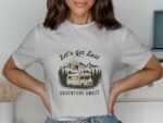 A woman wears a gray t-shirt featuring a camper van and mountains, with the text "Let's Get Lost" and "Adventure Awaits."