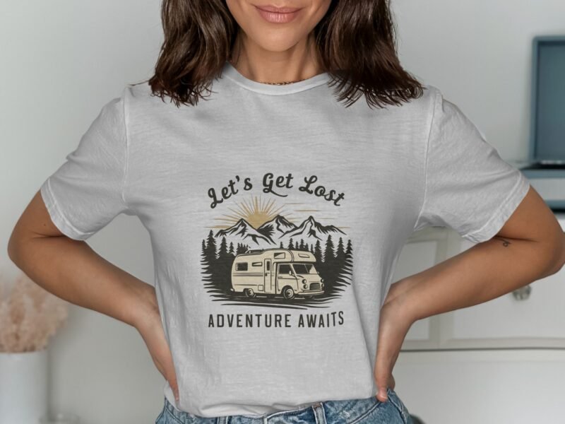A woman wears a gray t-shirt featuring a camper van and mountains, with the text "Let's Get Lost" and "Adventure Awaits."